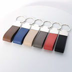 Set of six leather keychains in different colors on a light gray background